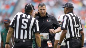 Miami head coach Mario Cristobal, center, argues a call with officials during the first half of an NCAA college football game against Duke , Saturday, Oct. 22, 2022, in Miami Gardens, Fla. (AP Photo/Wilfredo Lee)
