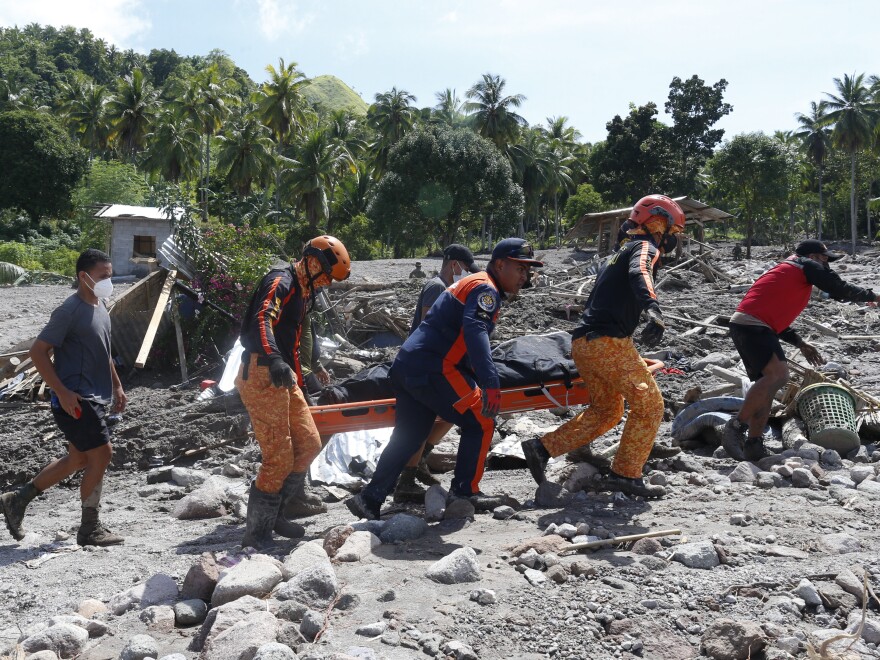 Rescuers carry a body at Maguindanao's Datu Odin Sinsuat town, southern Philippines on Sunday.