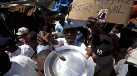 A protester holding an empty plate and a spoon chants anti-government slogans during a demonstration marking the 27th anniversary of the signing of Haiti's Constitution, in Port-au-Prince, Haiti, Saturday, March 29, 2014. (Dieu Nalio Chery/AP)