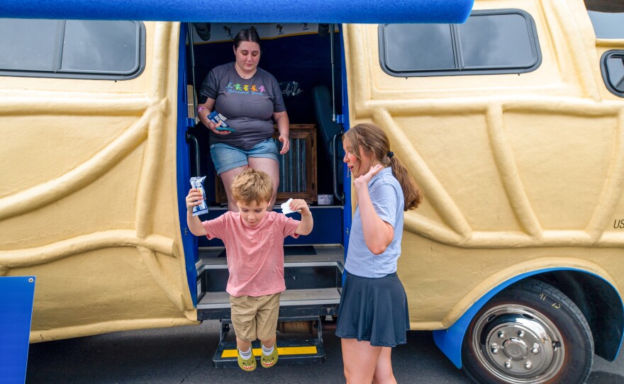 Alexander Ostopick, 4, leaps from the NUTmobile with his mom Mkensie behind.