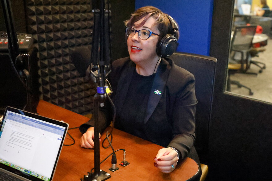 Mayor Barbara Buffaloe sits in a recording booth. She's wearing headphones and a dark blazer. She's speaking into a microphone.