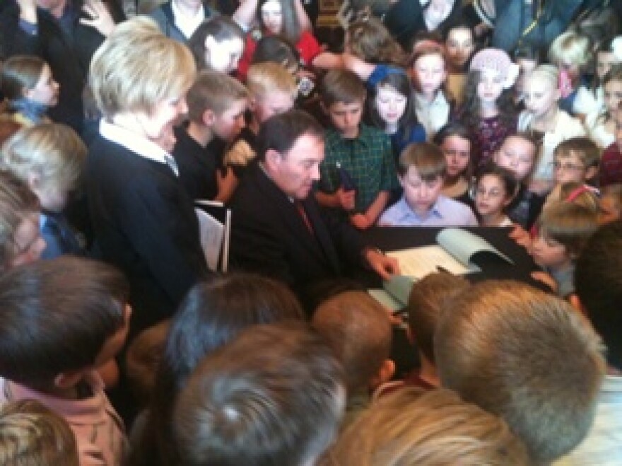 Utah Governor Gary Herbert signs HCR2, surrounded by 4th graders who lobbied to correct an error in Utah's state flag.