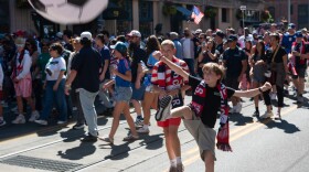 A child rooting for the U.S. men's soccer team kicks an inflatable soccer ball.