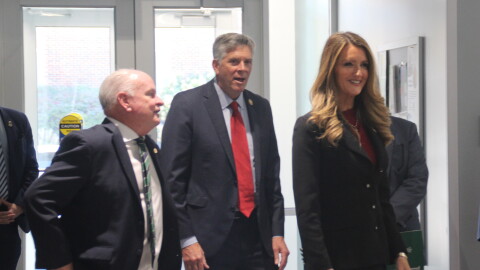 Local and federal officials enter a university building.