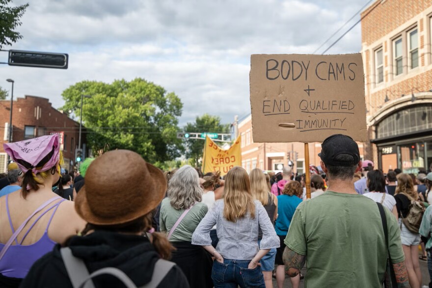People hold signs as they listen to speakers at a vigil for Corey Ruiz on Thursday, July 23, 2026, in Madison, Wis.