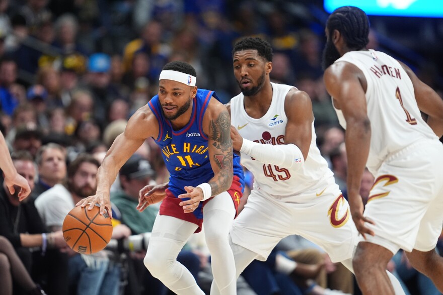 Denver Nuggets guard Bruce Brown, left, collects a loose ball as Cleveland Cavaliers guards Donovan Mitchell, center, and James Harden defend in the second half of an NBA basketball game, Monday, Feb. 9, 2026, in Denver. 
