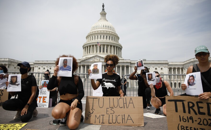 Protesters Heyssis Castillo and Katherine Bonilla (center left and right) demonstrate in front of the Capitol on Saturday.