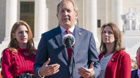 Texas State Rep. Shelby Slawson, left, and Texas State Sen. Angela Paxton, right, listen as Texas Attorney General Ken Paxton, center, speaks to anti-abortion activists at a rally outside the Supreme Court, Monday, Nov. 1, 2021, on Capitol Hill in Washington.