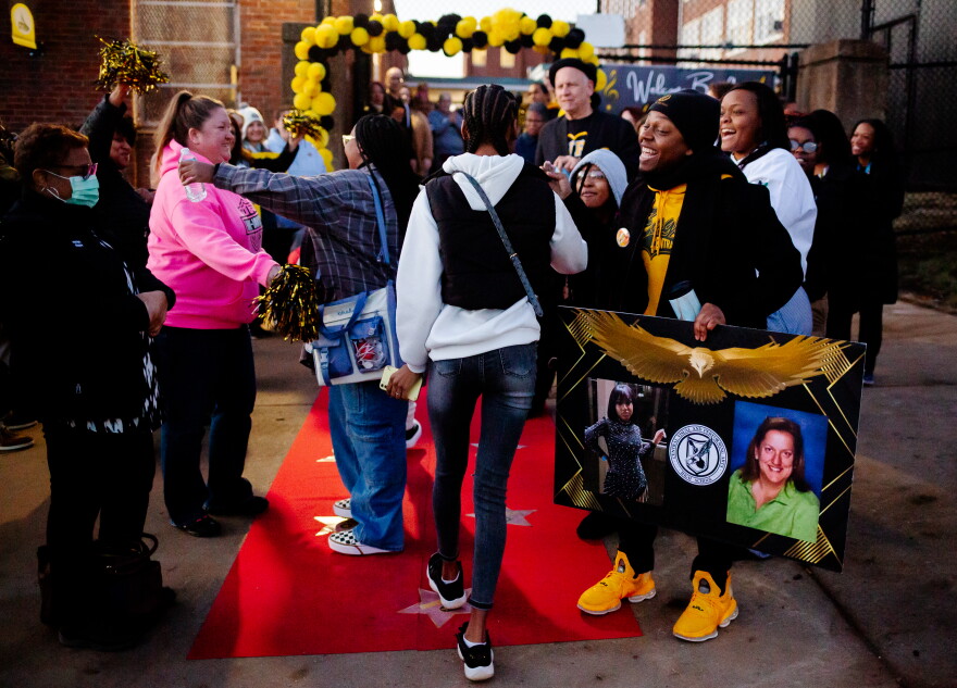 Jay Mitchell, right, a 31-year-old alumni of Central Visual and Performing Arts from Pagedale, welcomes hundreds of students back to school on Tuesday, Jan. 17, 2023, in south St. Louis. Today marks the first day students returned to the high school after an attack at the school last October that left two dead. Keisha Acres, 15-year-old victim Alexzandria Bell’s mother, stands behind Mitchell in white. 
