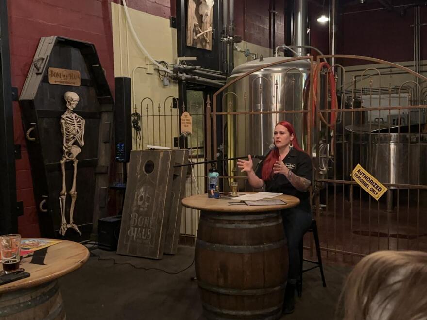 Woman standing behind barrel table in brewery