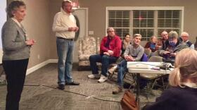 A room of constituents listen to a man and woman from Bloomington City Council at a town hall meeting.