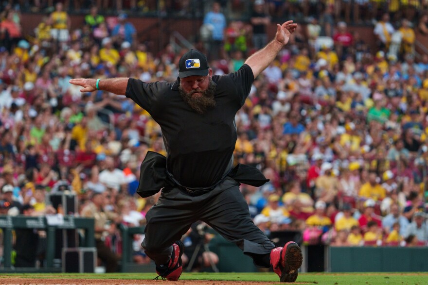 Vincent Chapman, the dancing umpire, does the splits during a baseball game between the Savannah Bananas and the Party Animals at Busch Stadium on Friday, July 18, 2025, in downtown St. Louis.