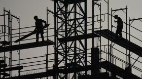 Workers stand on scaffolding on a residential building under construction. (Sean Gallup/Getty Images)