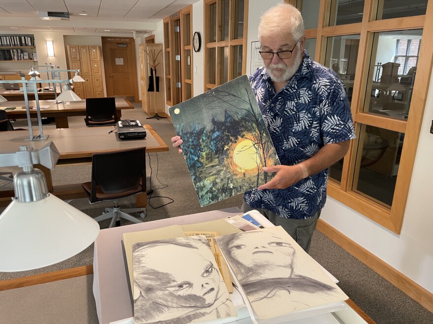 Librarian Emeritus Bill Ross shows off images of aliens from Betty and Barney Hill's collection at the University of New Hampshire Library.