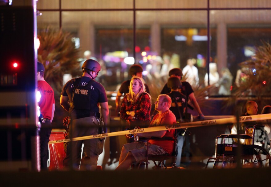 People wait in a medical staging area on Monday, after a mass shooting during a music festival Sunday on the Las Vegas Strip. Police say Stephen Paddock fired down at the crowd of more than 22,000 people from his room on the 32nd floor of the Mandalay Bay Resort and Casino.