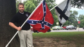 Robert Miller of Arkansas's chapter of the League of the South holds a Confederate battle flag and the LOS flag on Capitol grounds.