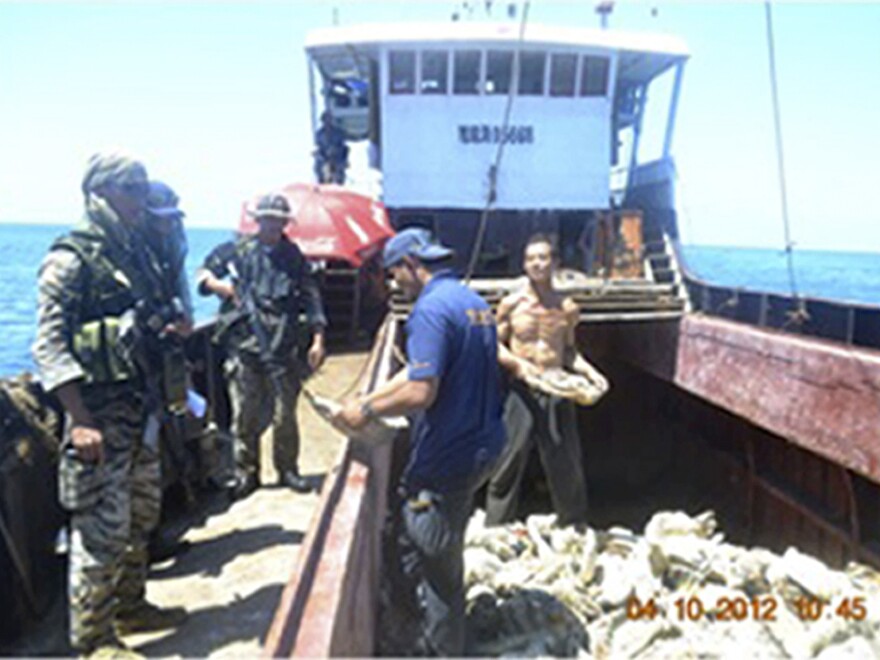 Filipino naval personnel look at giant clam shells onboard a Chinese fishing vessel at the disputed Scarborough Shoal in the South China Sea last month. Both countries claim the area, but say they are seeking a diplomatic solution.