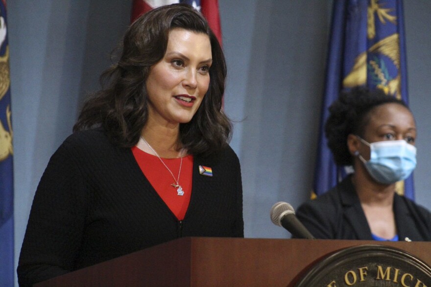 Whitmer speaking at a podium