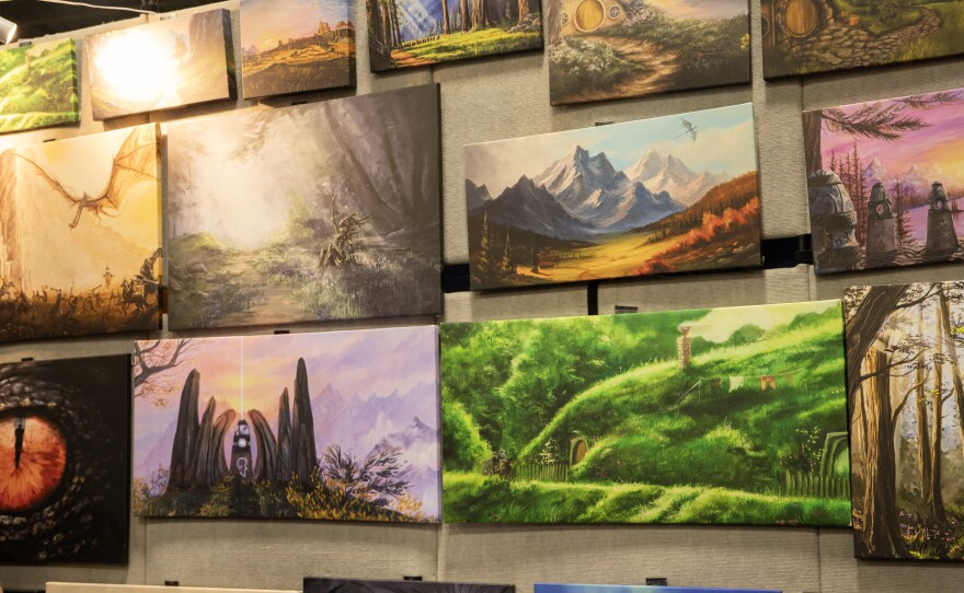 A selection of Aaron Long's original paintings for sale at Motor City Comic Con. Long said he loves to insert his favorite characters into traditional landscape paintings.