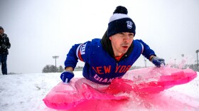 Riding an inflatable pool float, UConn student Nater Herman heads down a hill covered in fresh snowfall while sledding with Jackson Gearney (left), January 07, 2024. Both students work as student managers for the UConn Men’s basketball team and said they wanted to get some sledding in before the team practiced later in the day.