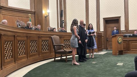 Washington state Supreme Court Justice Theo Angelis dons his robe alongside wife Kim and children Katherine and John as he is sworn in as a justice at the Temple of Justice on Monday, May 18, 2026, in Olympia.
