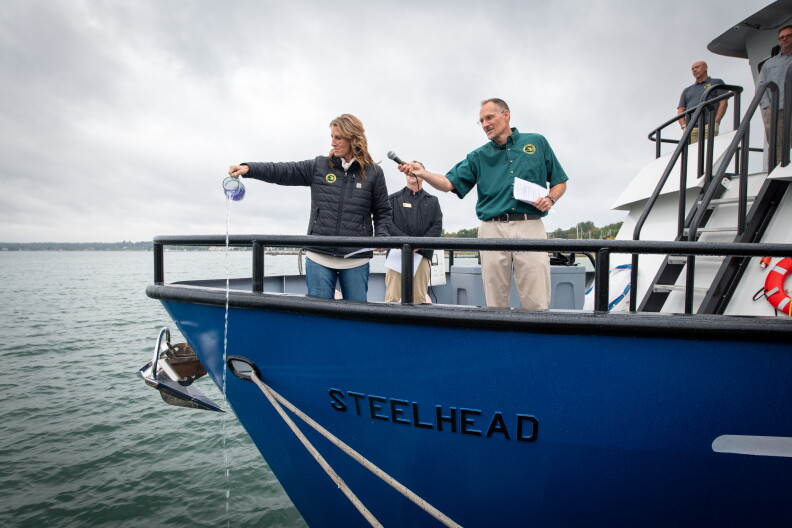 Michigan Department of Natural Resources Deputy Director Shannon Lot pours water over the bow of the RV Steelhead to christen it at the Sept. 30 ceremony.