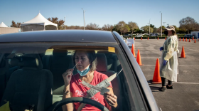 Photo of woman in car self-administering a COVID-19 test in California