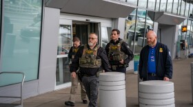Federal Immigration and Customs Enforcement agents walk outside the terminal at Cleveland Hopkins International Airport.