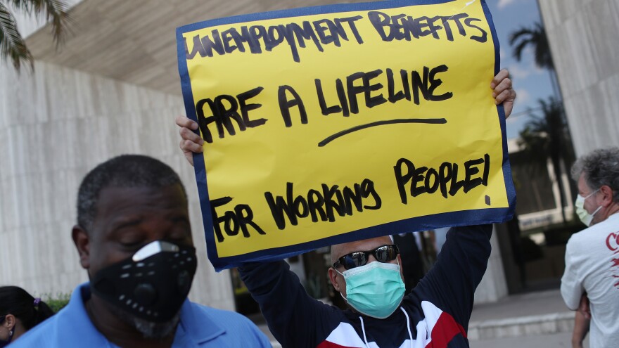 In this file photo, demonstrators in Miami Springs, Fla. ask senators to support the continuation of boosted unemployment benefits.