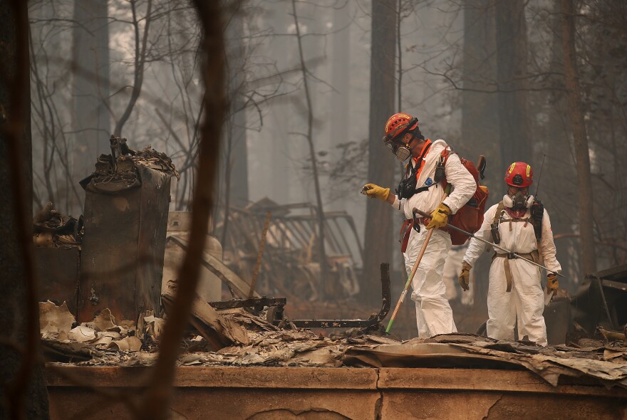 Rescue workers search for human remains on Thursday at a home that was burned by the Camp Fire in Paradise, Calif.