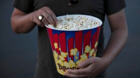 Person holding bucket of popcorn