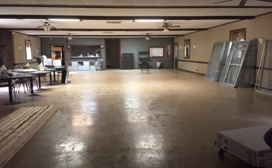 Large room with unassembled dog crates against the wall.  The room will be converted to house up to 30 kennels.