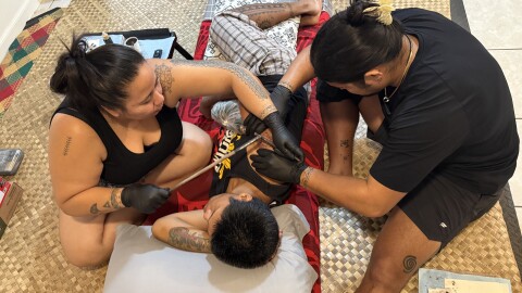 Natalia Roxas, left, tattoos Gabe Torno with the help of her student Michael Quintana on Oʻahu.