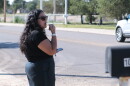 A woman stands beside the street leading to National Beef Tuesday, blowing a whistle and warning workers of federal immigration agents.