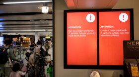 A screen displays an announcement on possible travel delays due to a global IT outage Gatwick Airport in Crawley, United Kingdom.