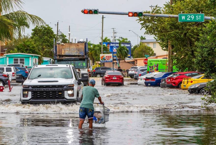 A man walks through the flood at West 14th Avenue and West 29th Street in Hialeah as torrential downpours inundate South Florida due to a disturbance off Florida’s coast on Thursday, November 16, 2023.