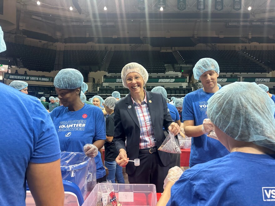 Tampa mayor Jane Castor smiles as she packs rice for meal pack event