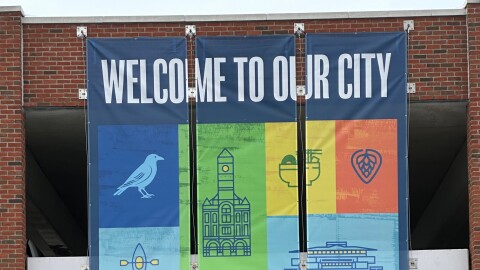 A "Welcome to our city" banner hangs from the side of a parking garage in downtown Springfield, Ohio.