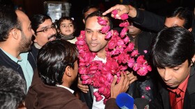 Pakistanis welcome Muhammad Shahid Nazir, center, the singer of "One Pound Fish," at Lahore's airport Thursday.