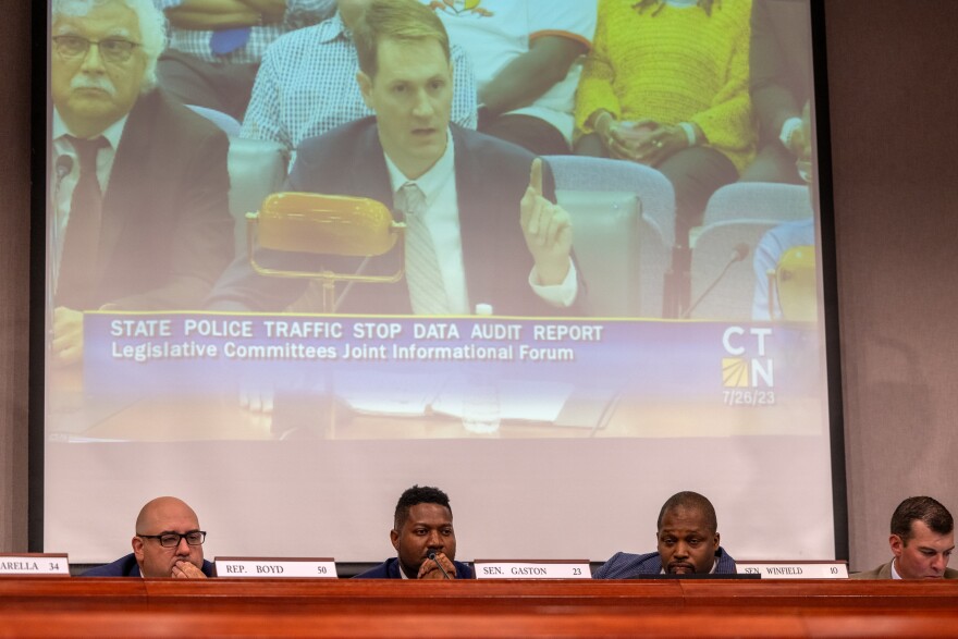 FILE: Members of the Judiciary and Public Safety committees listen to Ken Barone of the Connecticut Racial Profiling Prohibition Project (as seen on the projector) during a forum on state police traffic stop data on July 26, 2023.