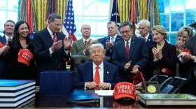 President Donald Trump smiles after signing a spending bill in the Oval Office