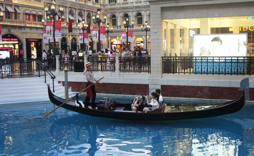 A gondolier serenades tourists at a replica of St. Mark's Square in the Venetian casino in Macau.