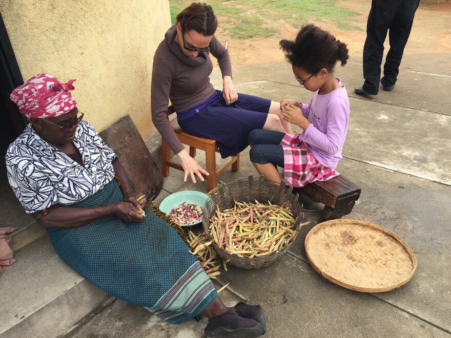 Gladys Mabaya (left) and her husband used income from their small farm to educate their 10 children. The author's wife, Krisztina Tihanyi, and their daughter, Izabella, help prepare beans for a meal during a Christmas visit to Zimbabwe.