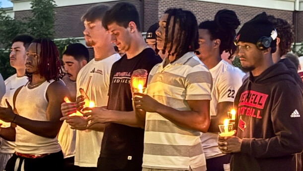 William Jewell football players hold candles during the vigil for MichaJo Barnett.