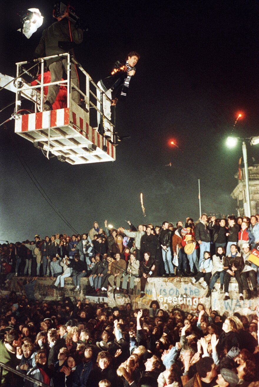 David Hasselhoff hovers in the cage of a hoisting crane above the Berlin Wall and sings "Looking for Freedom" on Dec. 31, 1989.