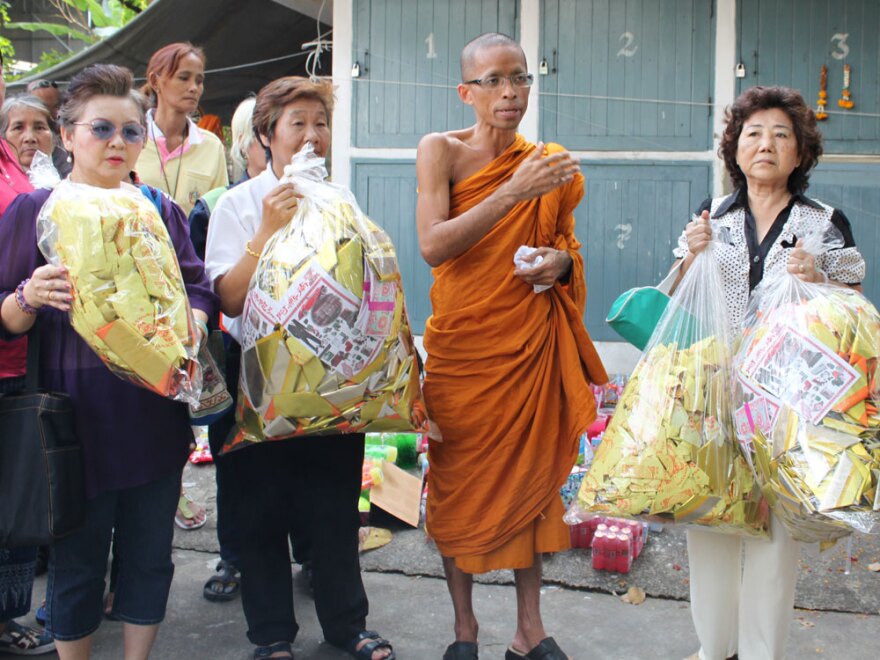 Buddhist monk Somprasong Panyavajiro stands in front of the mortuary with followers holding bags of paper money offerings  for the spirits of the fetuses. The temple's spokesman said the monks were unaware of the corpses in the mortuary. Three people have been arrested so far in the case.
