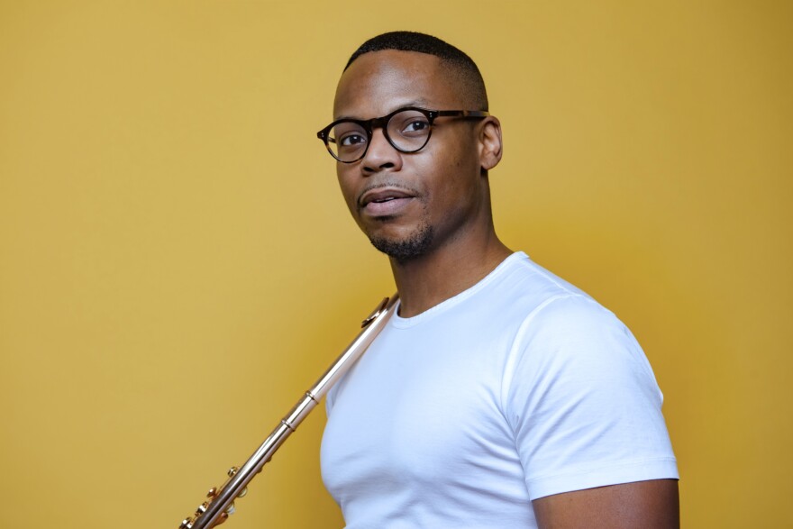 yellow background, closeup of flutist Brandon Patrick George holding instrument