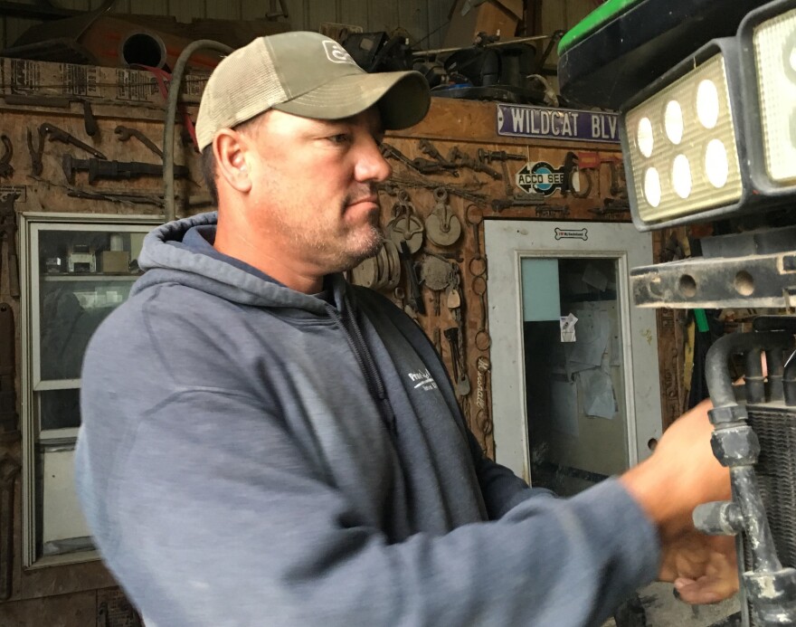 Luke Ulrich repairs a tractor on his farm near Baldwin City, Kan.