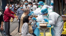 Medical workers take swab samples from residents to be tested for the COVID-19 coronavirus, in a street in Wuhan in China's central Hubei province on May 15, 2020.  (STR/AFP via Getty Images)