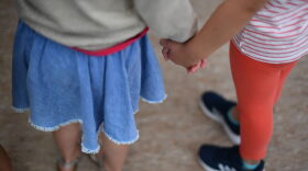 Children hold hands at a nursery school.
